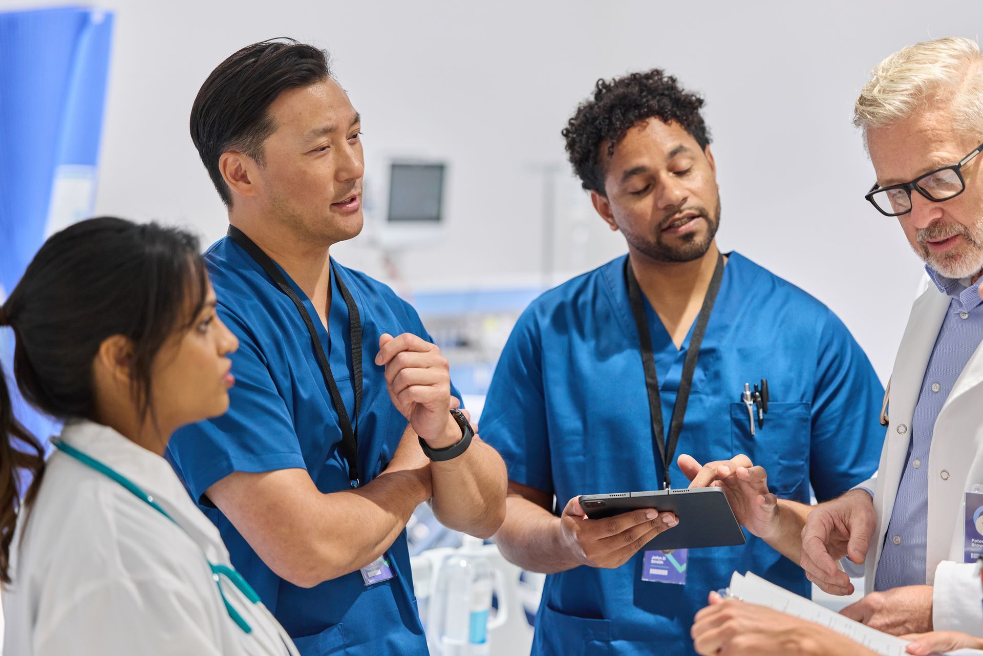 Male nurse and GP discussing patient care during a consultation in a clinic setting. Male nurse and GP discussing patient care during a consultation in a clinic setting.