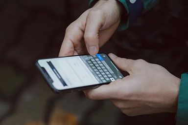 Person holding a smartphone and typing on the virtual keyboard.