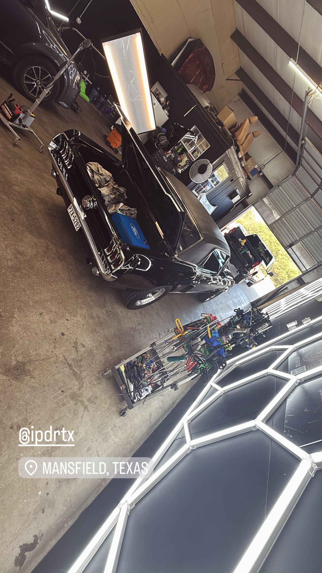 Garage with black car being worked on; Mansfield, Texas.