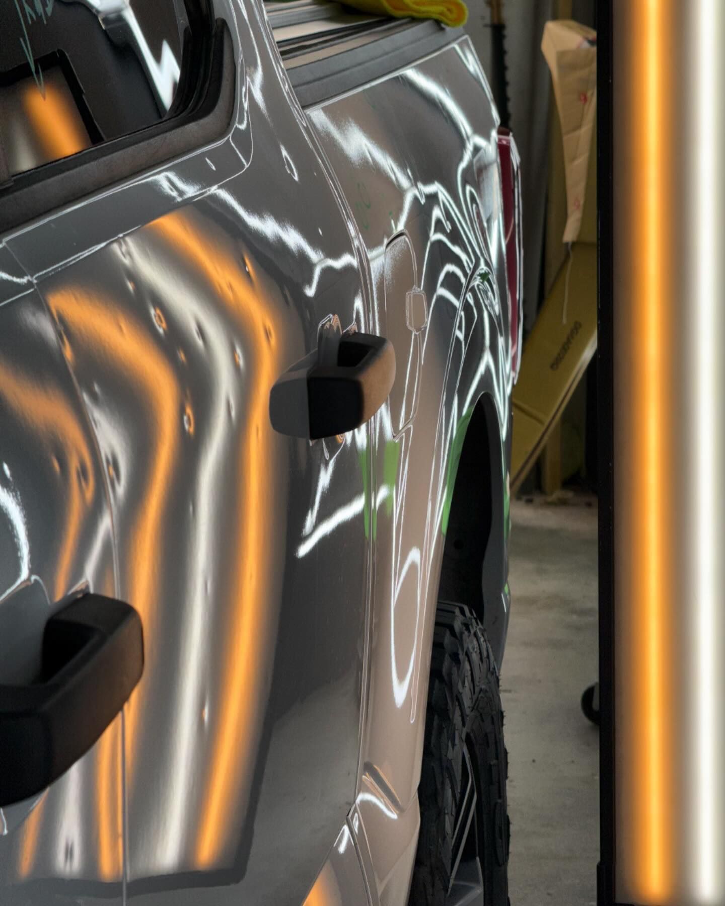 Truck door with reflective light showing dents being repaired.