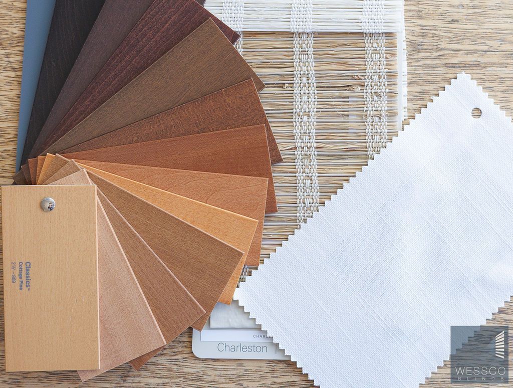 Color swatches in various shades of brown and beige, alongside white fabric samples on a wooden surface.