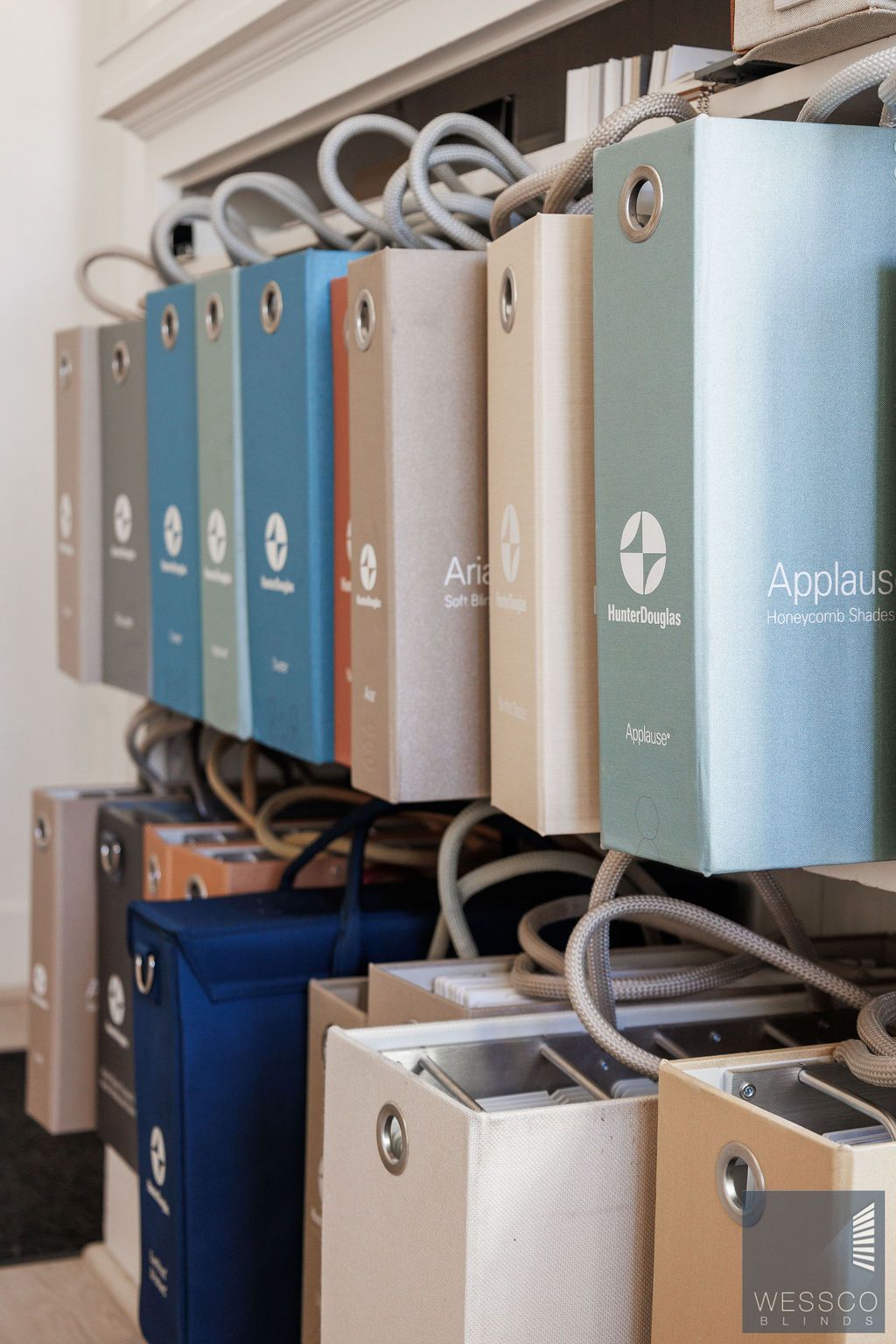 Collection of colorful fabric swatch books hanging on metal rods.