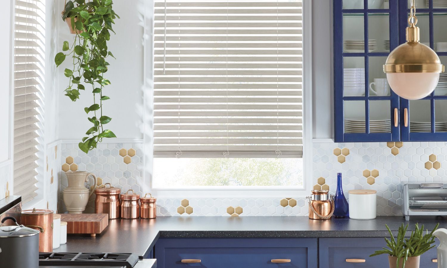 Cordless window blinds from Hunter Douglas installed in a kitchen window, surrounded by blue cabinetry 