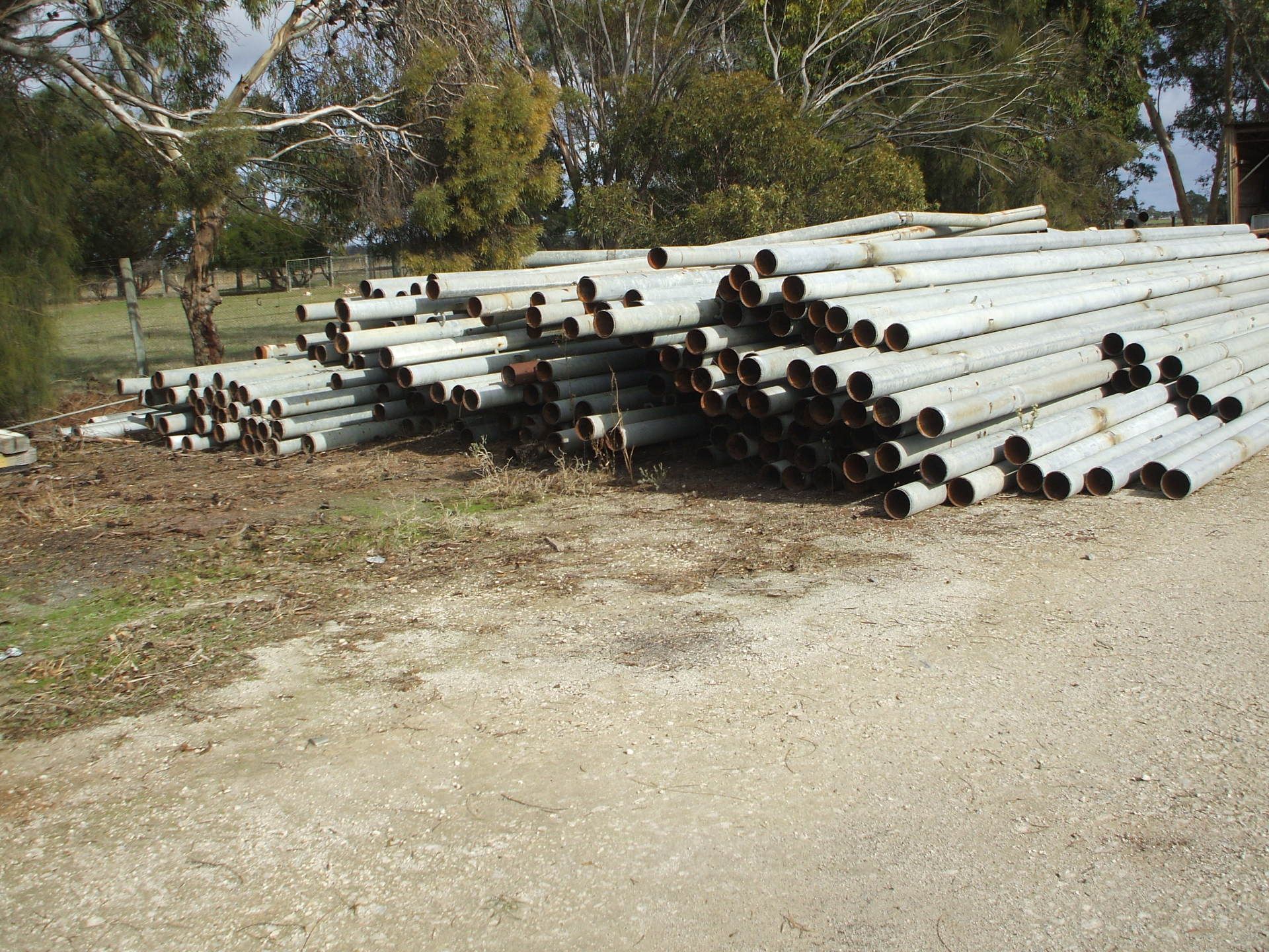 Pipes stacked on side of road