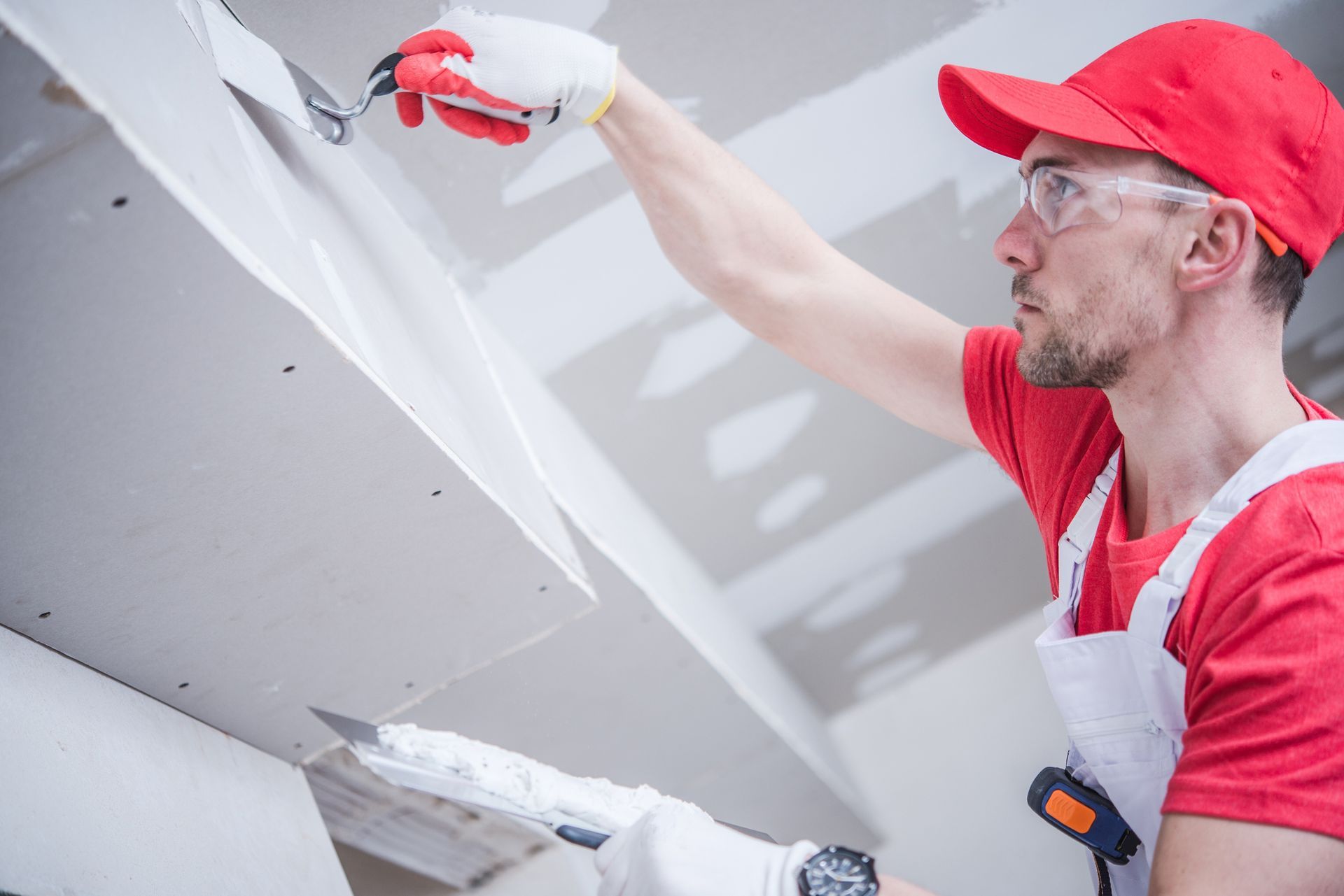 A man is plastering a wall with a spatula.