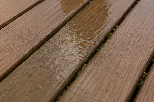 Close-up of wet brown wooden deck boards with water droplets