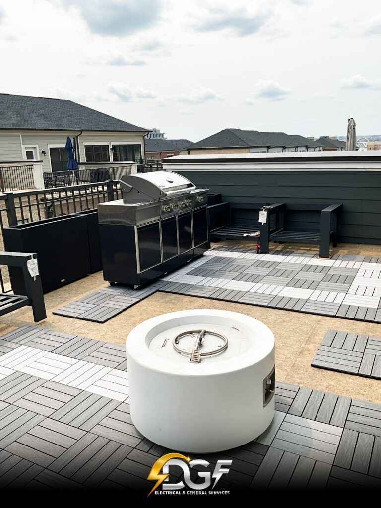 A rooftop deck with a fire pit and a grill.