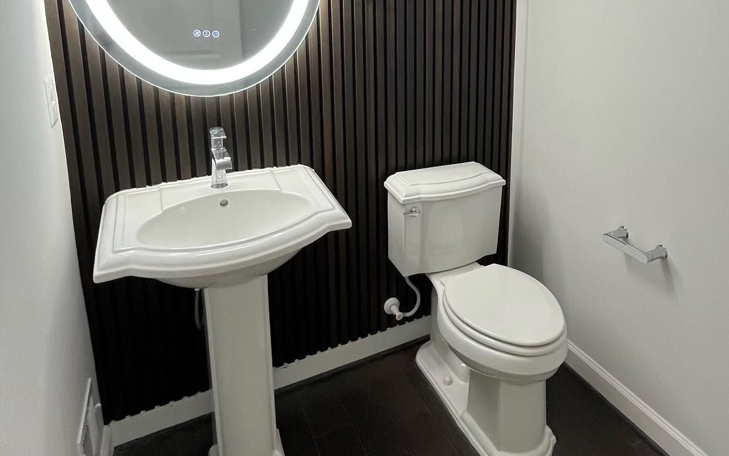 A bathroom with a sink , toilet and mirror.