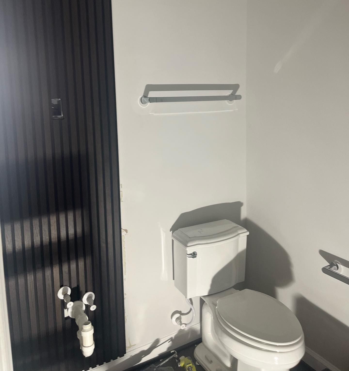 A bathroom with a toilet and a towel rack