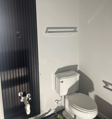 A bathroom with a toilet and a towel rack