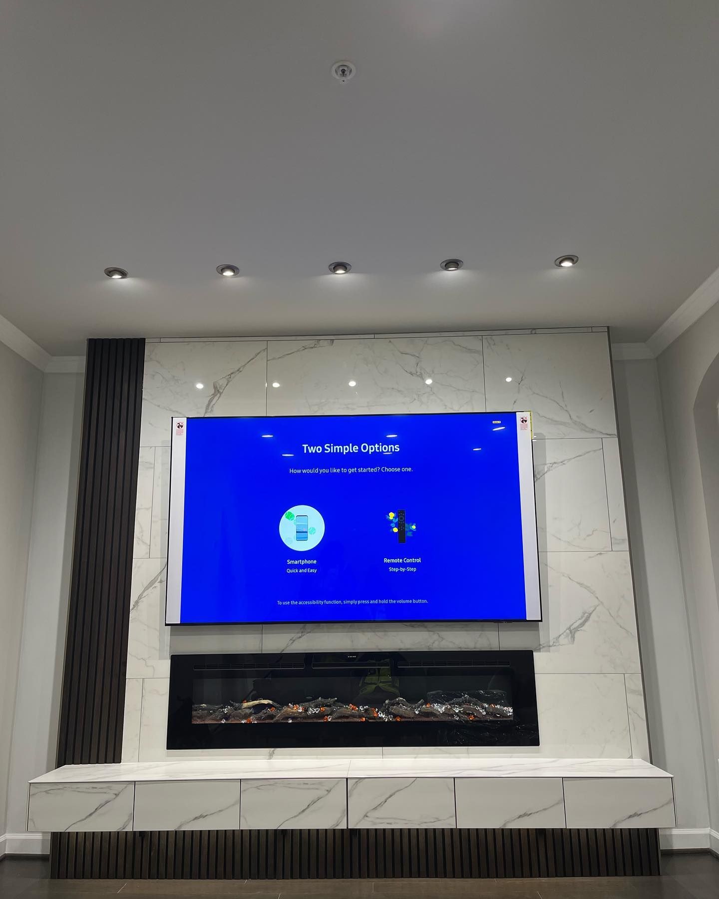 A living room with a fireplace and a flat screen tv