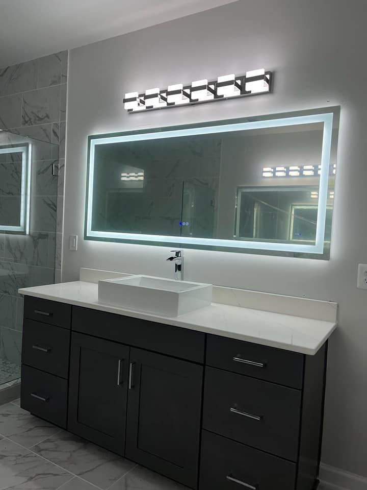 A bathroom with a sink and a large mirror.
