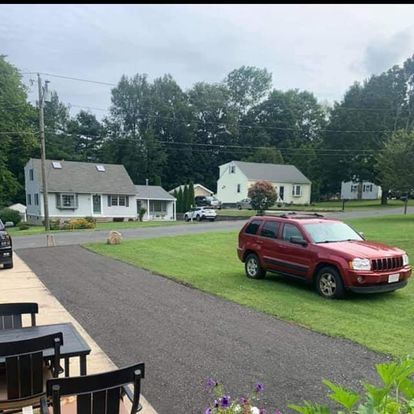 A red jeep is parked on the side of the road