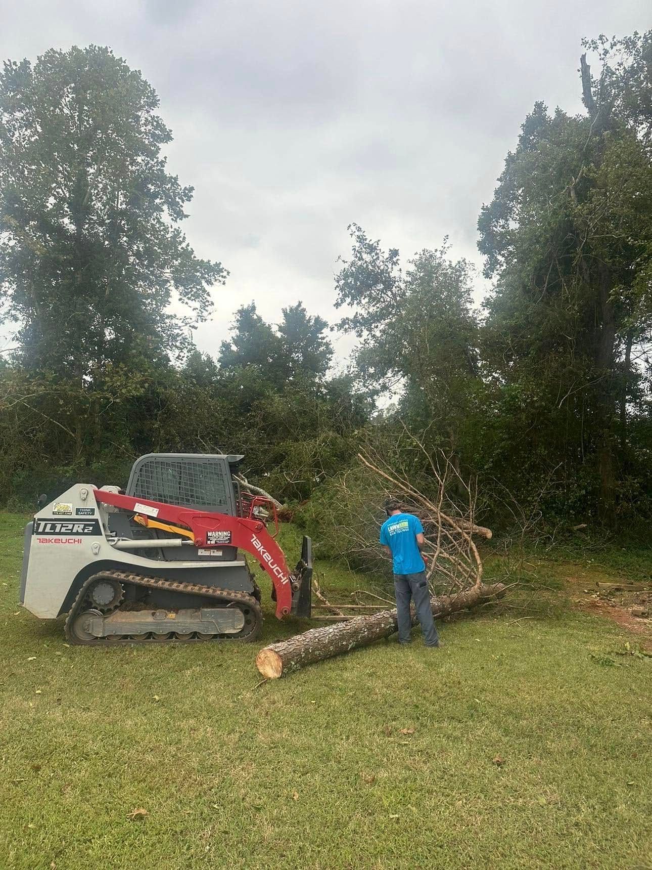 A man is standing next to a bulldozer in a grassy field.