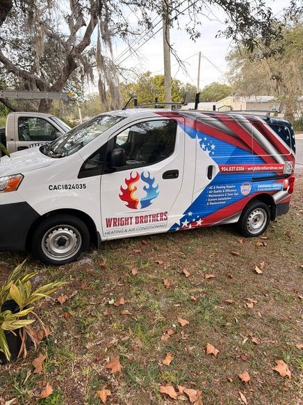 White Wright Brothers service van with red, white, and blue graphics, parked on grass.