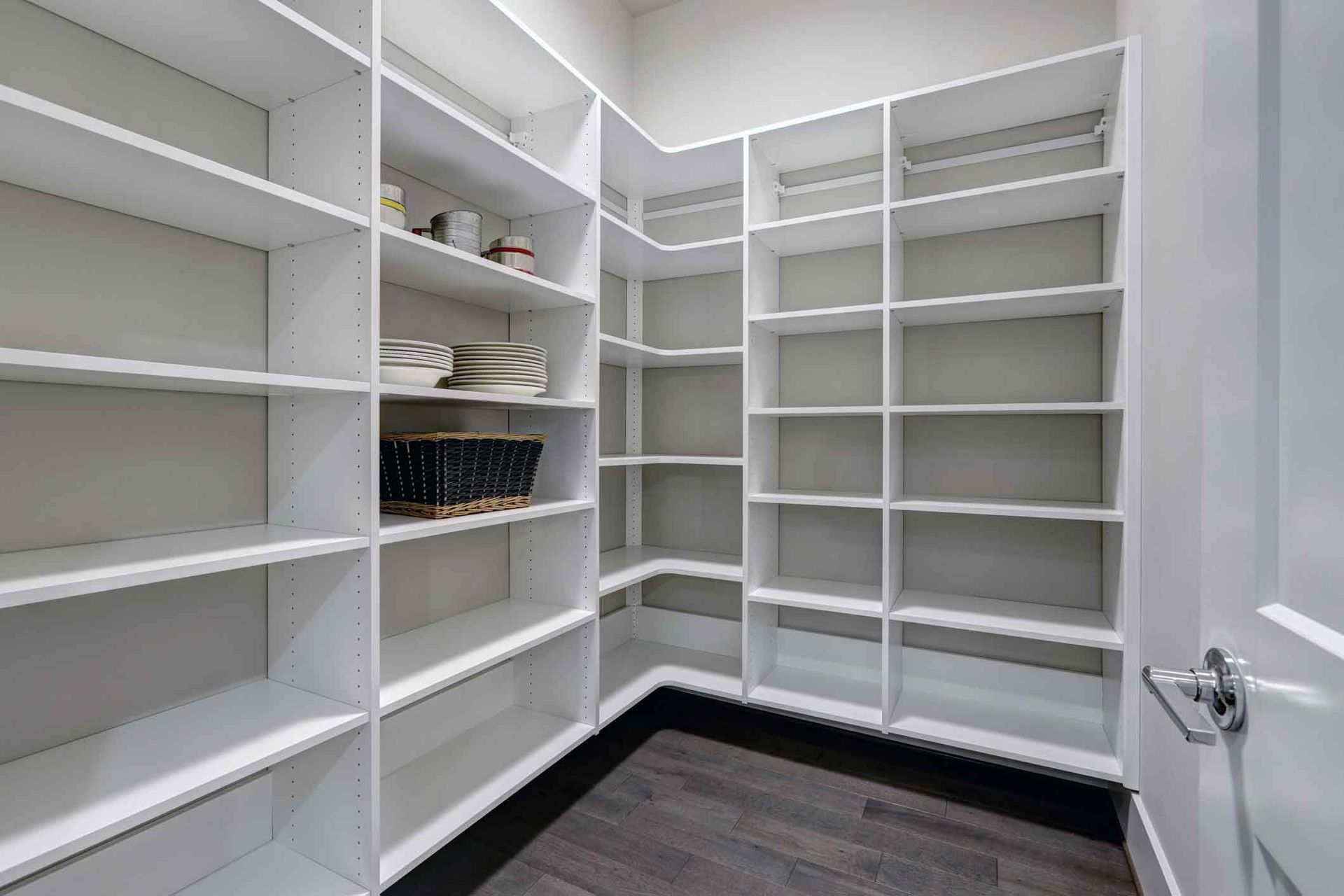 A walk in pantry with lots of shelves and a door.
