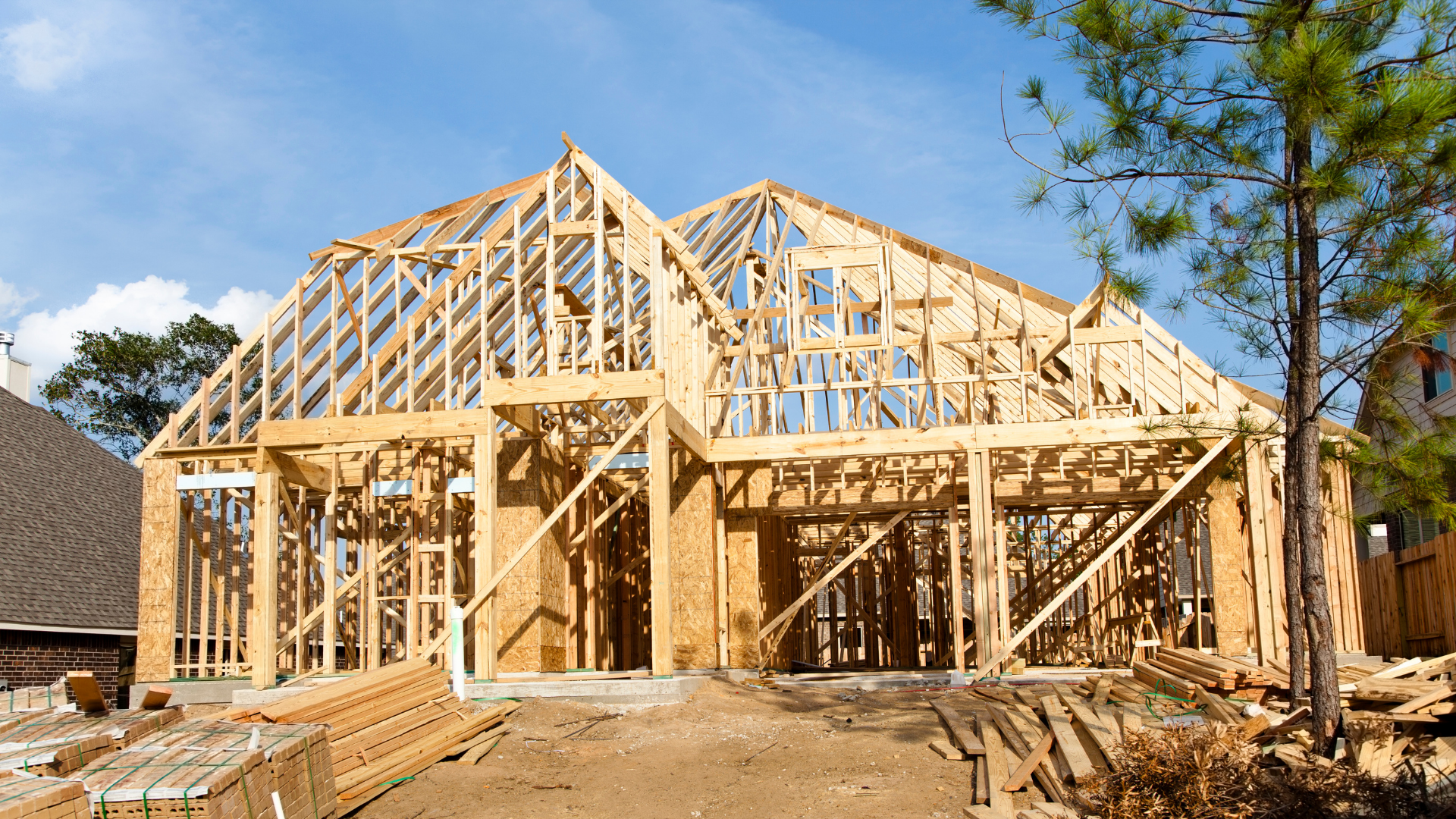 Wooden frame of a house under construction; bright, sunny day.