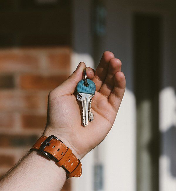 Hand Holding Keys With A Blue Cap Attached To A Tan Leather Watch — CQR Locksmiths In Inverell, NSW