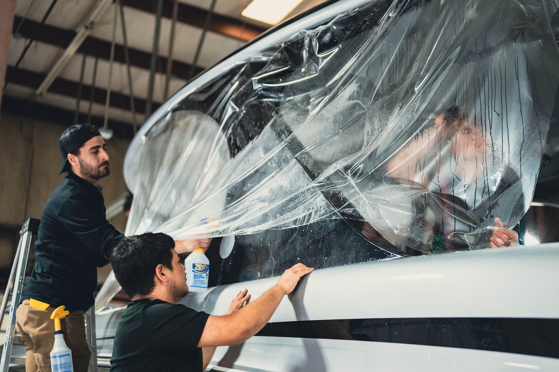a black porsche is parked in a parking lot with its door open