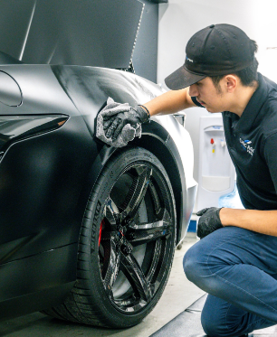 A man is cleaning a car with a cloth