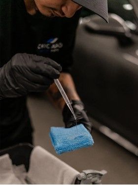 A man is cleaning a car with a sponge and a pipette.