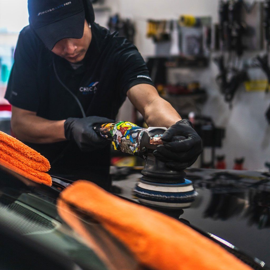 A man is polishing a car with a machine
