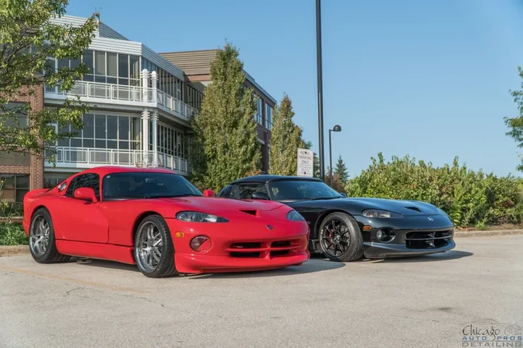 Two dodge viper cars are parked next to each other in a parking lot.