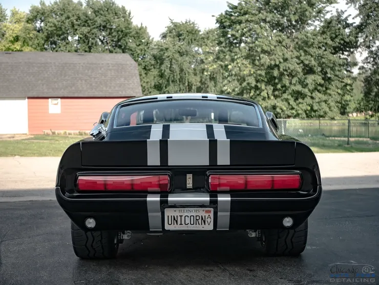 A black car with a license plate that says unicorn