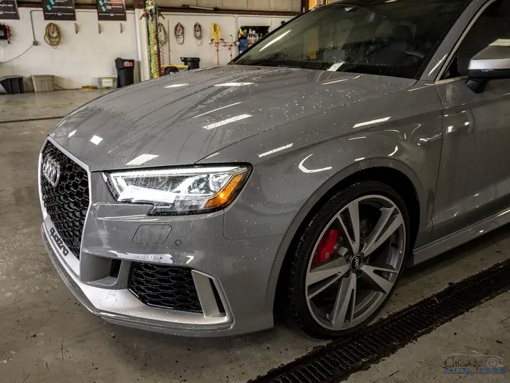 A gray audi rs3 is parked in a garage.