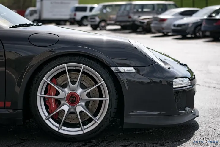 A black porsche 911 gt3 rs is parked in a parking lot.