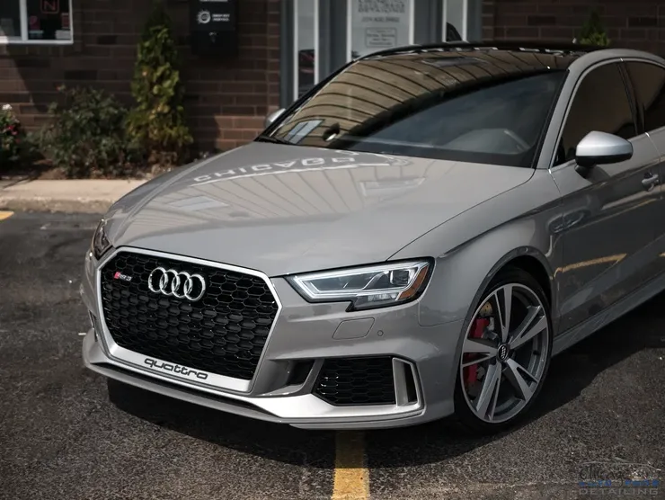 A silver audi rs 3 is parked in a parking lot