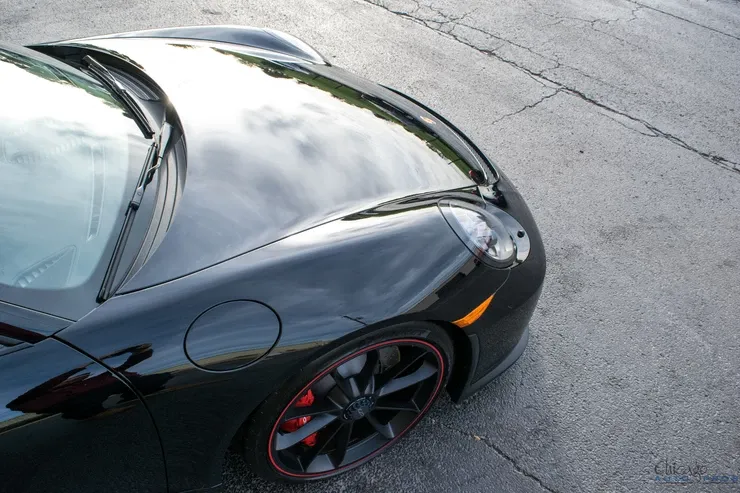 A black sports car is parked on the side of the road