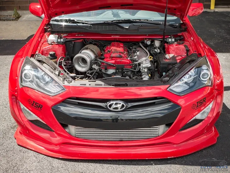 A red car with the hood up and the engine visible