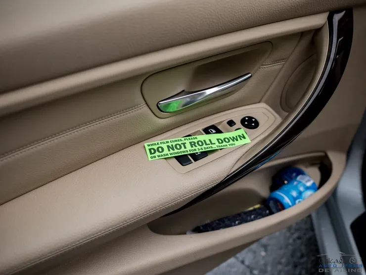 A car door with a do not roll down sticker on it