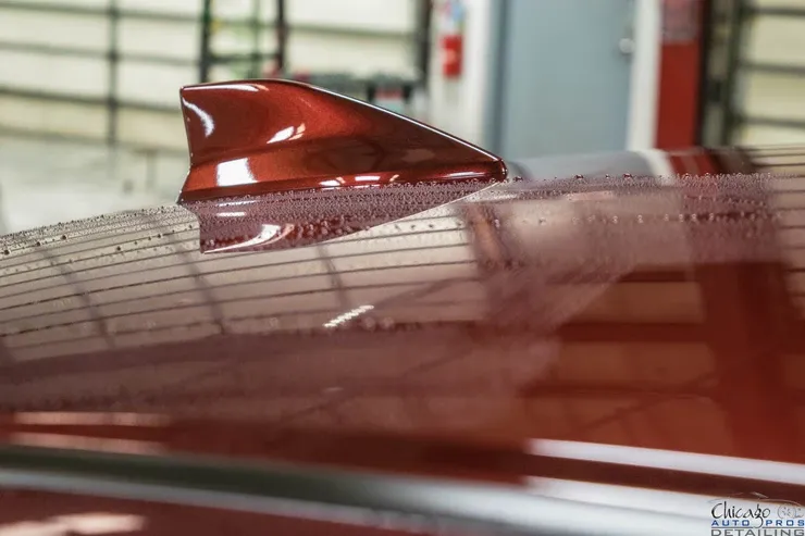 A red car with a shark fin on the roof