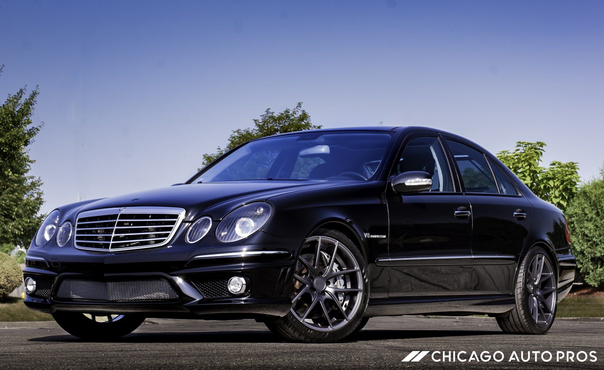 A black mercedes benz is parked on the side of the road