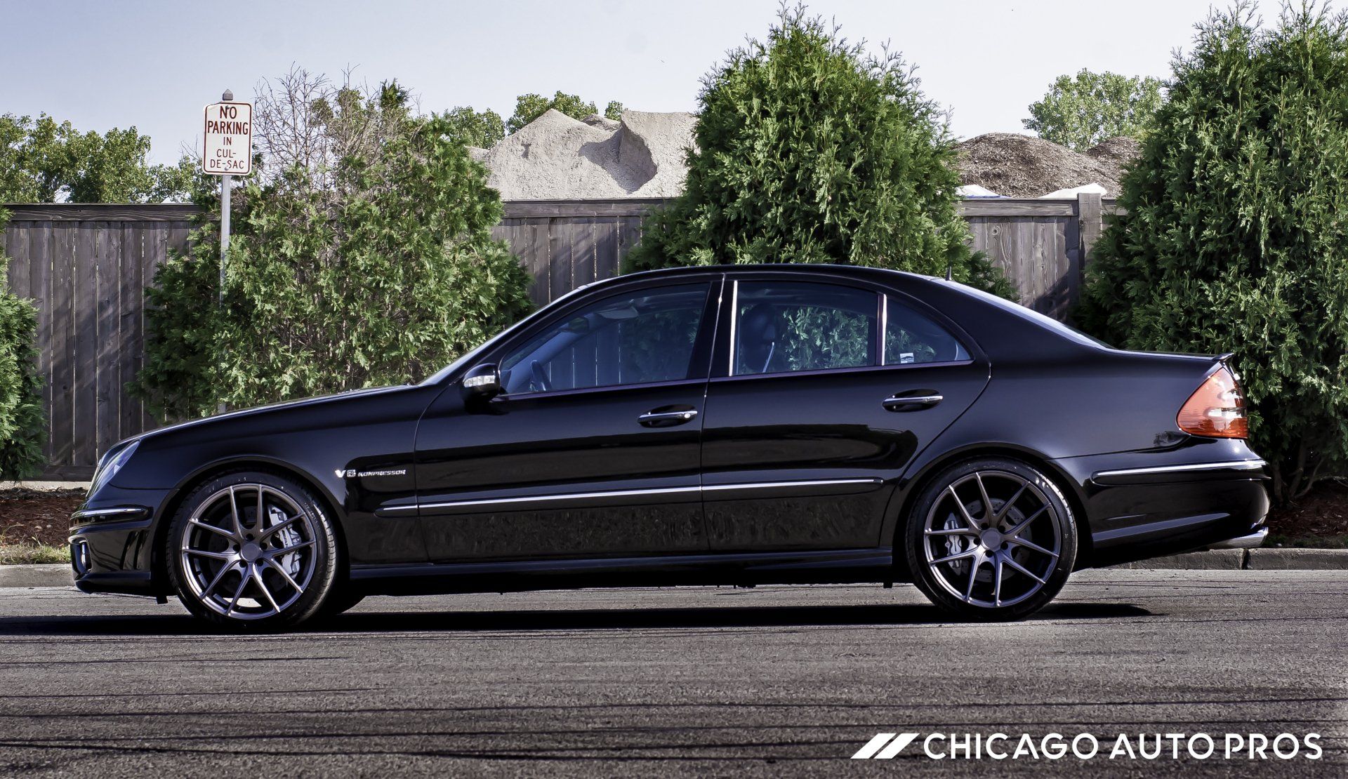 A black mercedes benz is parked on the side of the road