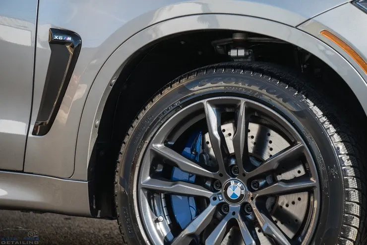 A close up of a bmw x5 with blue brake calipers