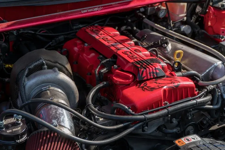 A close up of a red car engine with a turbocharger.