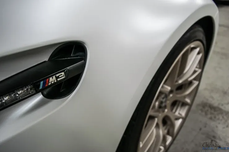A close up of the side of a silver bmw m3.