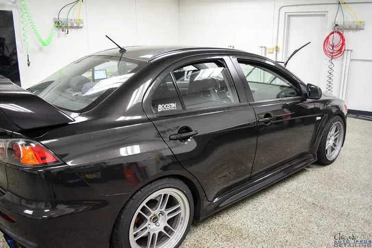 A black car is parked in a garage with a sticker on the side that says ' blitz '