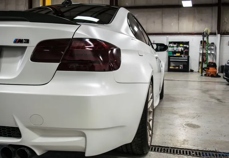 A white bmw m3 is parked in a garage.