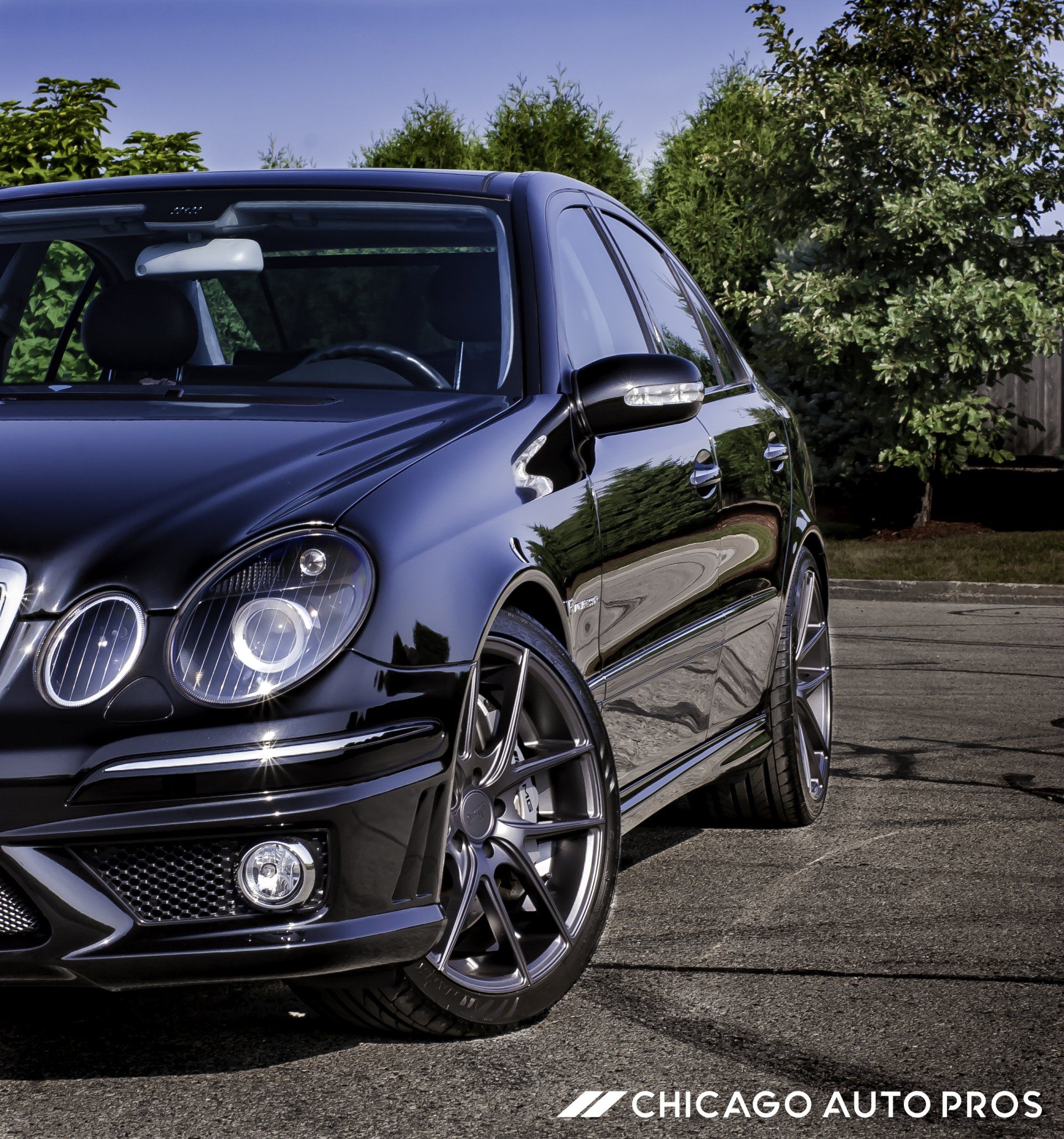 A black car is parked in a parking lot by chicago auto pros