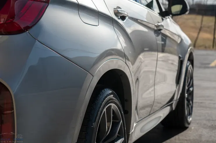A silver car is parked on the side of the road.