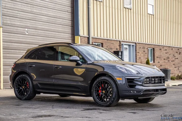 A porsche macan turbo is parked in front of a building.
