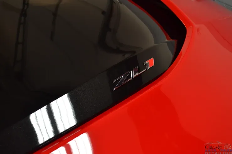 A red car with a zl1 sticker on the windshield