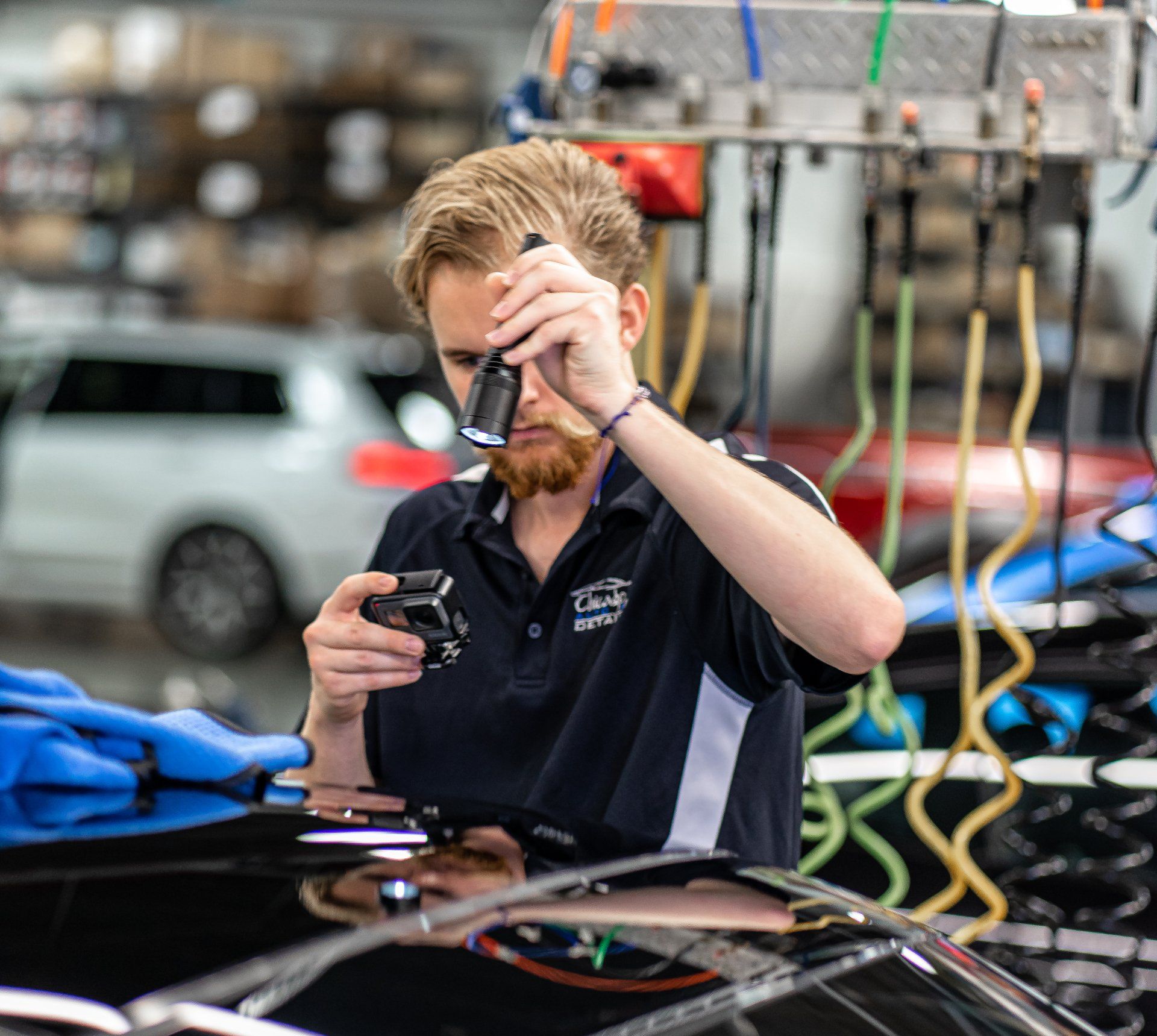 A man is working on a car with a gopro camera
