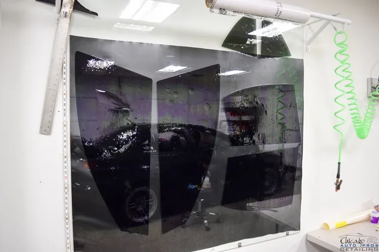 A car is reflected in a mirror in a garage.