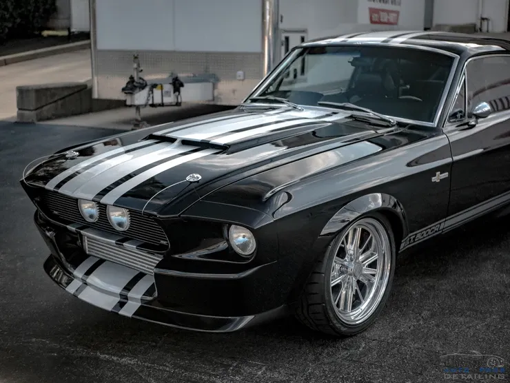 A black and white mustang is parked in a parking lot.