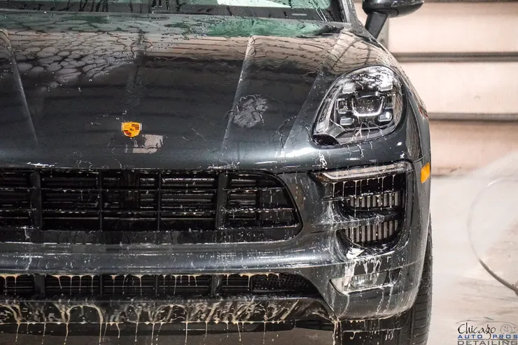 A black porsche macan is sitting in a garage.